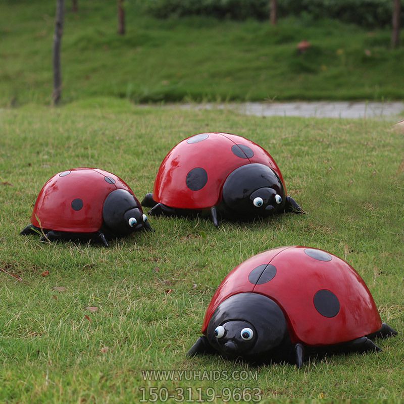 草地上摆放的三只红色玻璃钢彩绘瓢虫雕塑