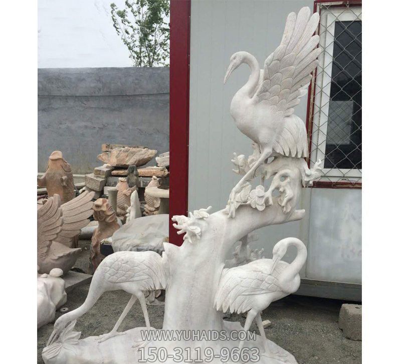 景区汉白玉石雕树干上的鹤雕塑