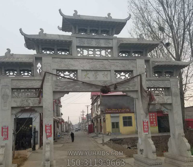 村庄道路口摆放三门五楼石牌楼雕塑