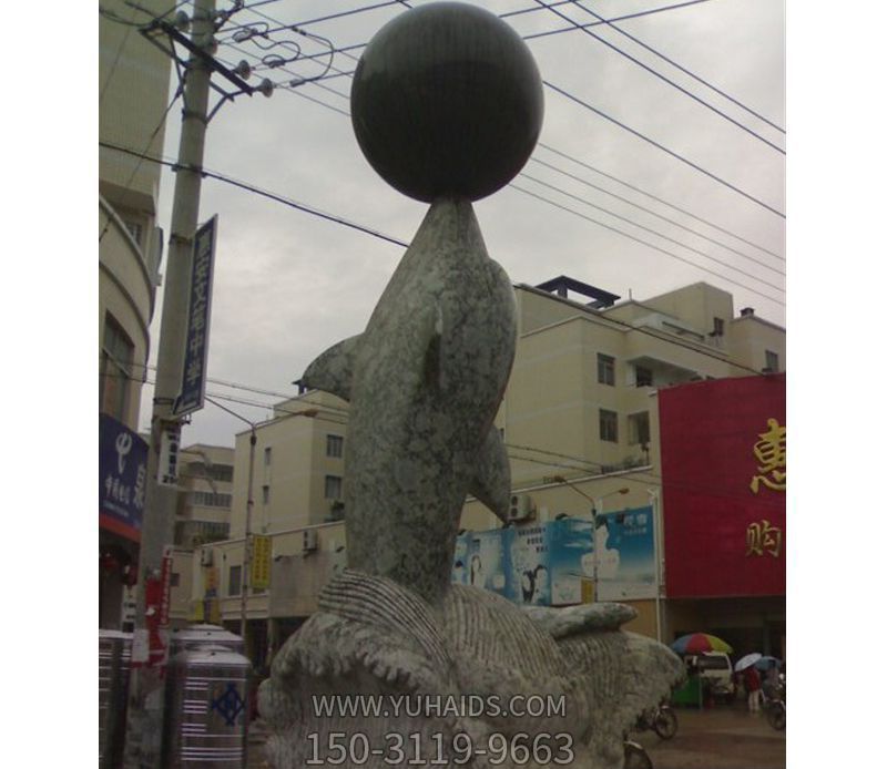 城市街道一只玩球的石雕海豚雕塑