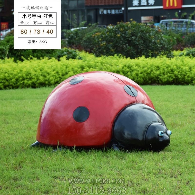 草地上摆放的一只红色小号玻璃钢彩绘瓢虫雕塑