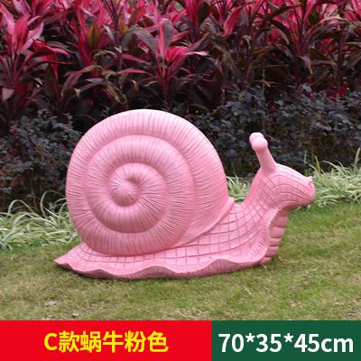 草地上摆放的粉色爬行玻璃钢彩绘蜗牛雕塑