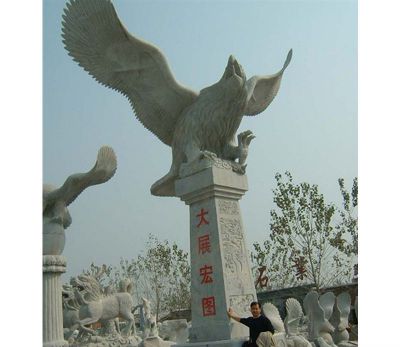 室外街边一只大型飞翔的石雕老鹰雕塑