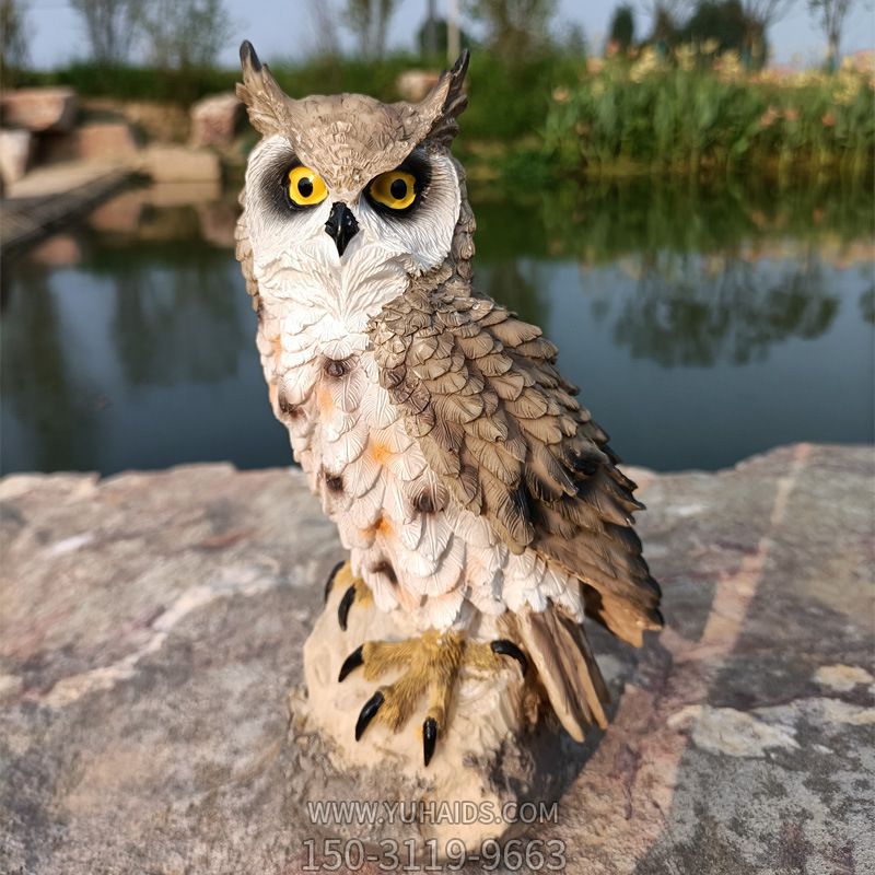 河边摆放一只树脂彩绘猫头鹰雕塑