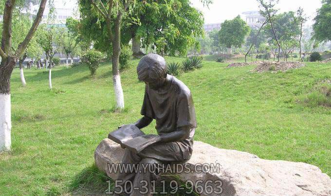 公园草坪玻璃钢仿铜坐着石头上的男孩读书雕塑