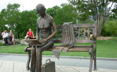 公园铜雕坐在长椅上看电脑的女孩雕塑
