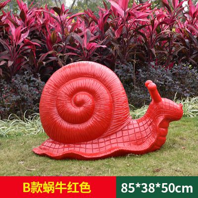 草地上摆放的红色的玻璃钢彩绘蜗牛雕塑