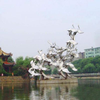 公园湖边摆放不锈钢镜面飞翔仙鹤群景观雕塑