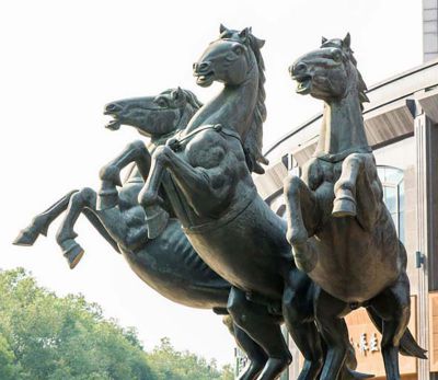 广场上摆放的三只玻璃钢喷漆马群雕塑