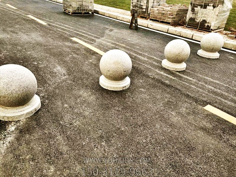 小学路边摆放球形隔离车路障石雕塑