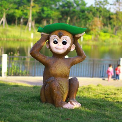 公园草地上摆放的头戴树叶的玻璃钢猴子雕塑