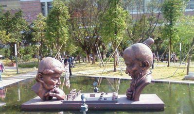 公园下中国象棋和国际象棋的抽象人物景观铜雕