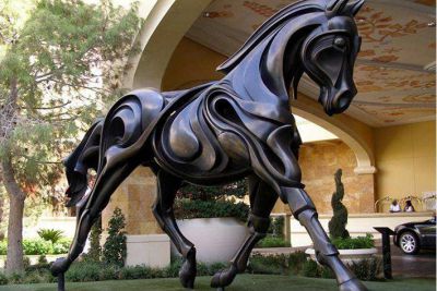 草地上摆放的黑色的不锈钢创意飞马雕塑