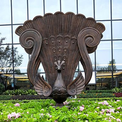 花池里一只傲立的不锈钢做旧孔雀雕塑