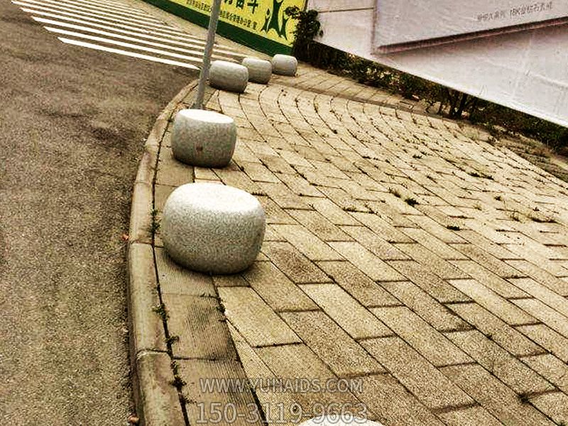 步行街边摆放鼓形挡车石雕塑