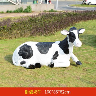 草坪中一只卧地休息的玻璃钢奶牛雕塑