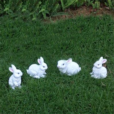 草坪四只玩耍的白色兔子雕塑