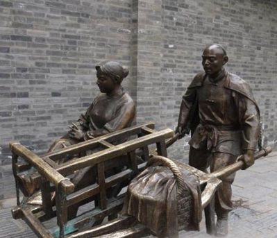 步行街摆放铸造推独轮车的人物黄铜雕塑