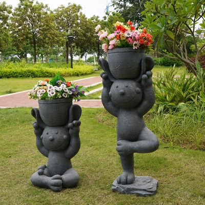 户外练瑜伽的石雕头顶花盆的兔子雕塑