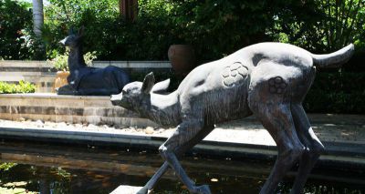公园池塘中的大理石石雕鹿雕塑