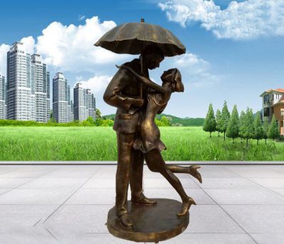 公园铜雕打伞接吻的情侣雕塑