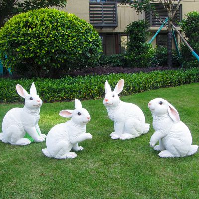 小区花丛中四只白色玻璃钢兔子雕塑