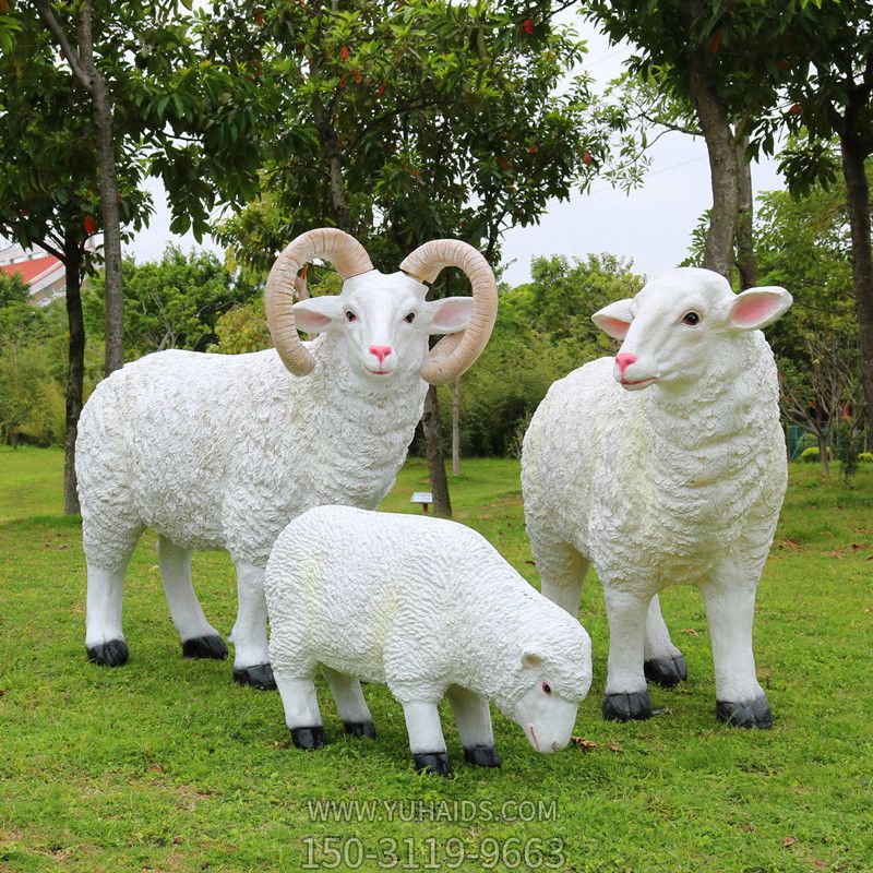 景区草地上摆放的一只吃草两只直视的玻璃绵羊雕塑