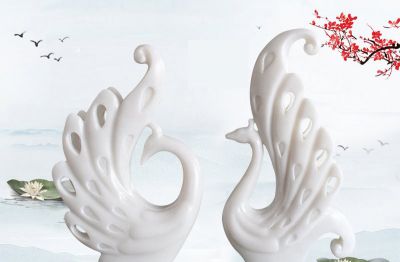 湖边摆放的两只相对的玻璃钢镂空孔雀雕塑