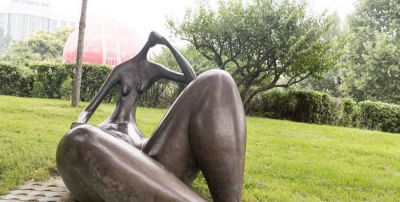 公园草坪坐着的抽象景观铜雕女孩雕塑