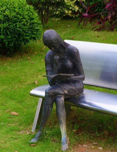 公园铜雕坐着长椅上的女孩读书雕塑
