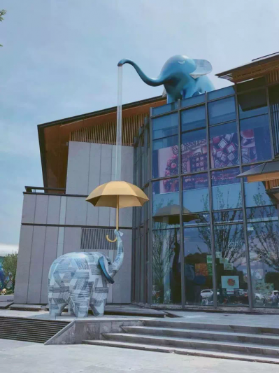 酒店创意玻璃钢喷水打伞的大象雕塑