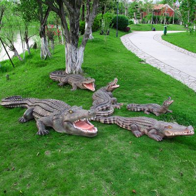 公园草地上摆放的形态各异的玻璃钢鳄鱼雕塑