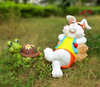 公园草坪上玻璃钢彩绘休息的兔子和乌龟雕塑