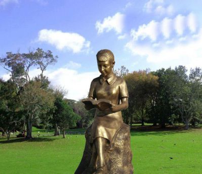 公园草坪女孩坐着石头上的读书雕塑