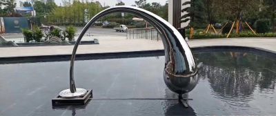 公园池塘中抽象弯腰的水滴雕塑