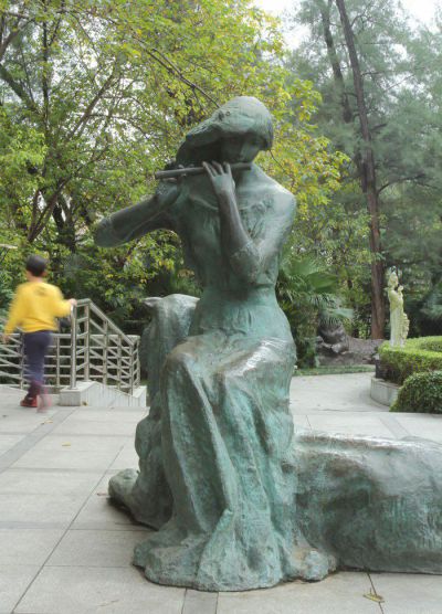 公园坐着吹笛子的女孩人物铜雕吹奏到时