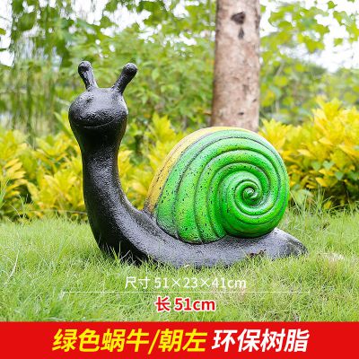 草地上摆放的绿色朝左的树脂创意蜗牛雕塑