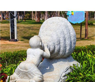 景区小孩趴着吹螺号的景观石雕吹奏雕塑