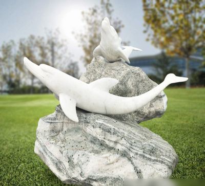 公园石头上趴着两只石雕海豚雕塑