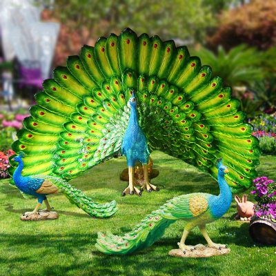 公园里有一只开屏和两只拖着尾巴散步的玻璃钢彩绘孔雀雕塑