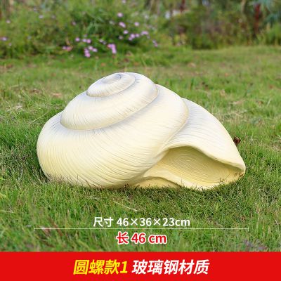 草地上摆放的圆形的玻璃钢仿真海螺雕塑