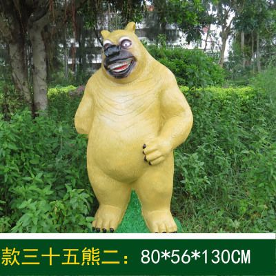 花池边摆放着一只捧腹大笑的玻璃钢卡通熊出没雕塑