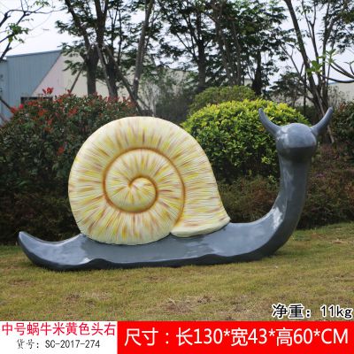 草地上摆放的米黄色的玻璃钢擦彩绘蜗牛雕塑