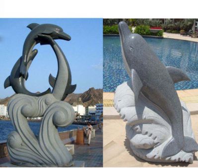 海边三只黑色石雕和一只抬头石雕海豚雕塑