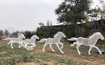 公园里摆放的四匹奔跑的不锈钢镂空马群雕塑