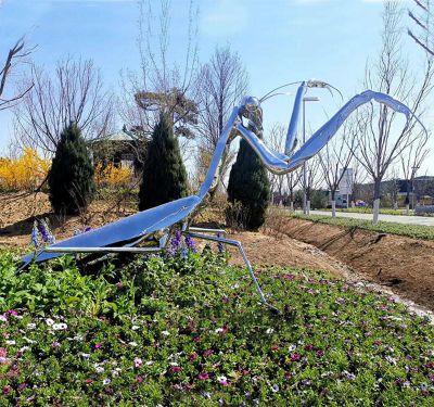 公园花丛里摆放的银色的玻璃钢创意螳螂雕塑