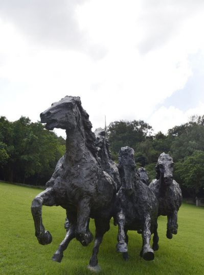 公园里摆放的一群玻璃钢抽象马群雕塑