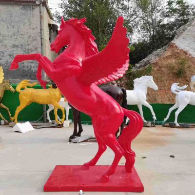 公园里摆放的一只红色的玻璃钢喷漆飞马雕塑